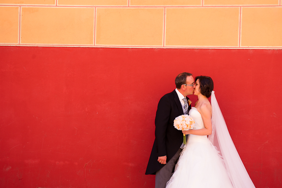 beso novios reportaje de boda pared roja amarilla Artycam fotografía León