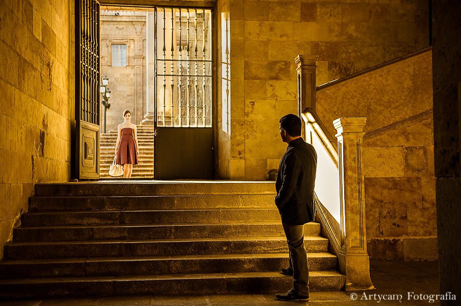 Fotografía de anuncio chica entrando puerta chico esperando arquitectura puerta naranja escaleras antiguo colonia Salamanca